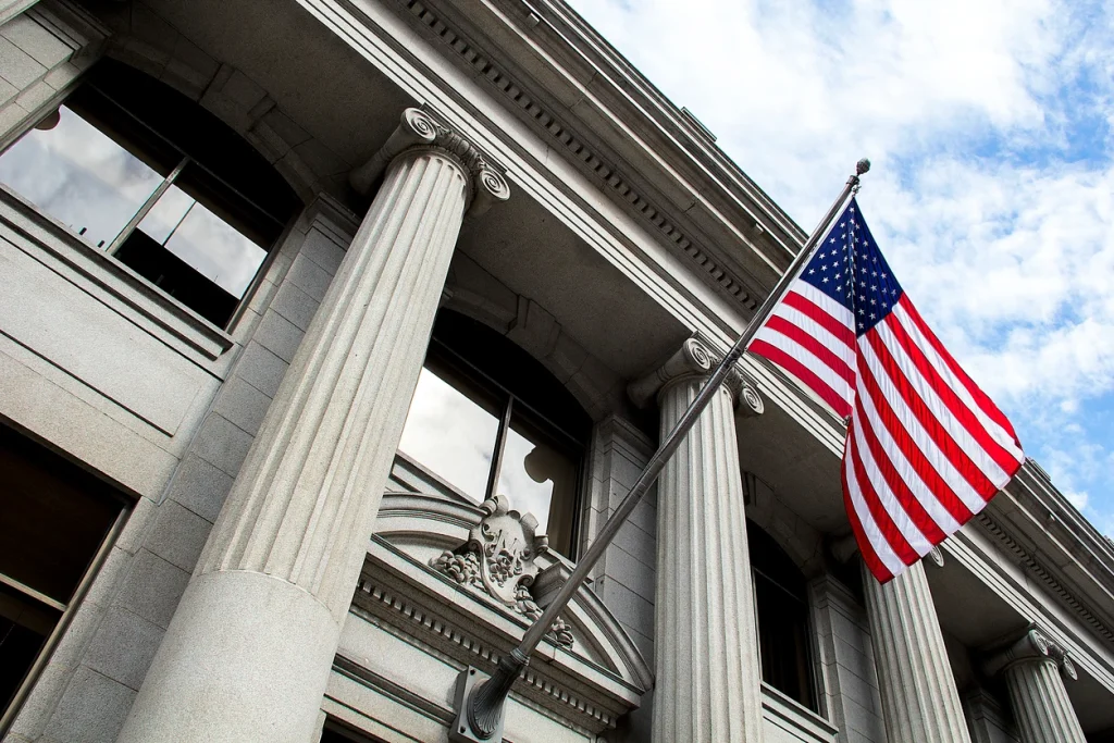  American flag flying over a government building. Our experienced lawyers are dedicated to defending you against accusations of fraud in Houston.